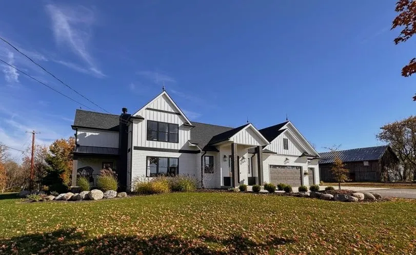 Modern farmhouse remodel with white board-and-batten siding in Ada, MI