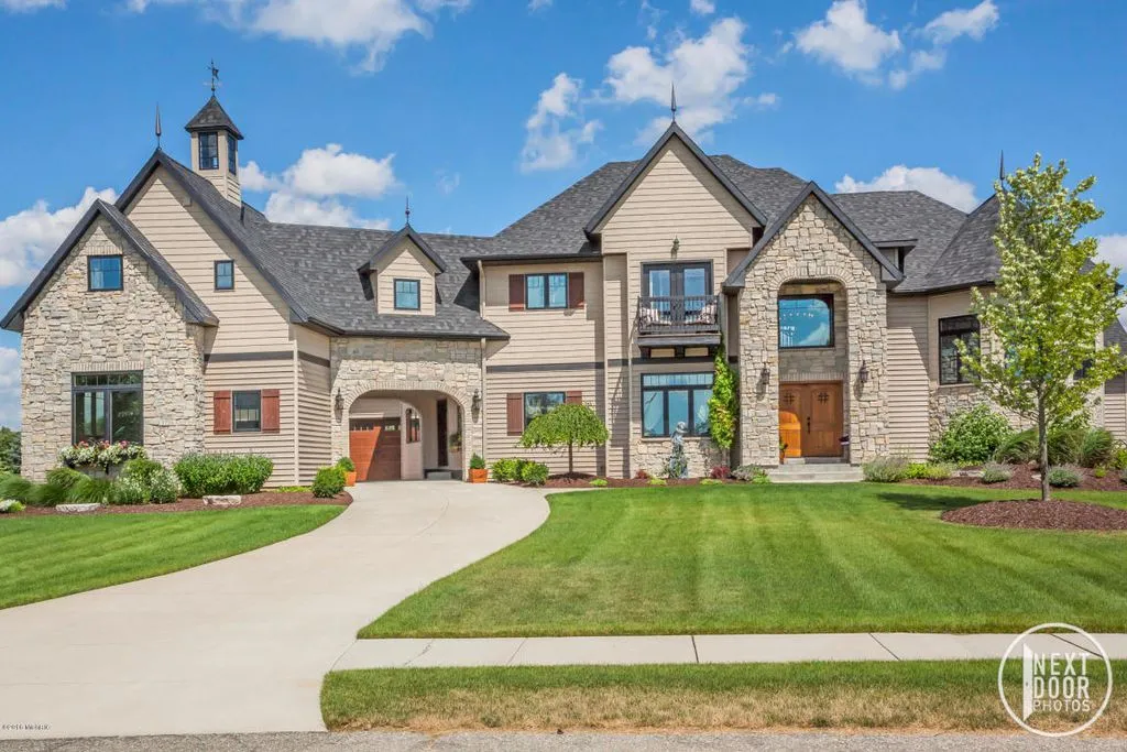 Custom home new construction with a stone front and cupola, built by Scheidel Construction in West Michigan